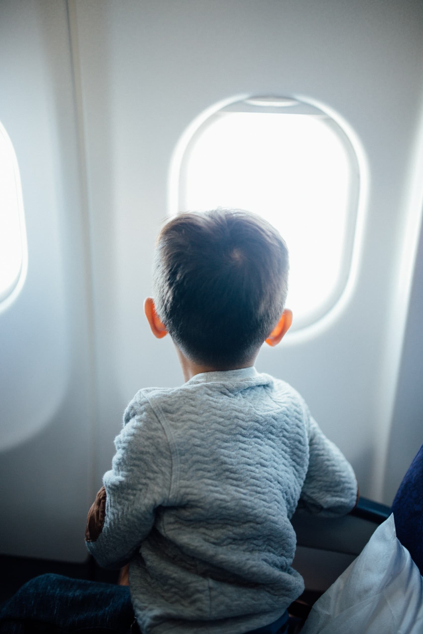 Kind blickt aus dem Flugzeugfenster