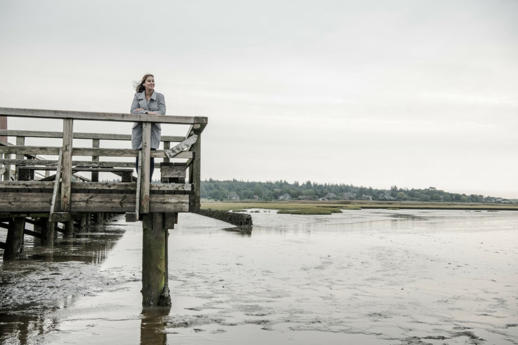 Frau steht in Huseum am Wattenmeer