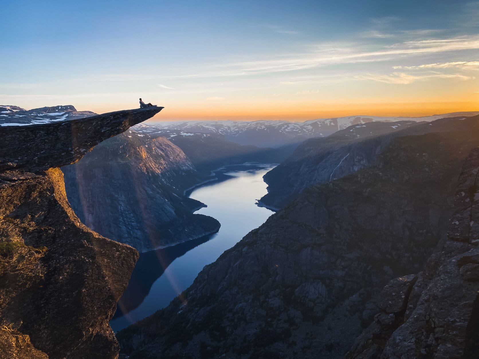 Mann auf Fels in Trolltunga genießt Aussicht 