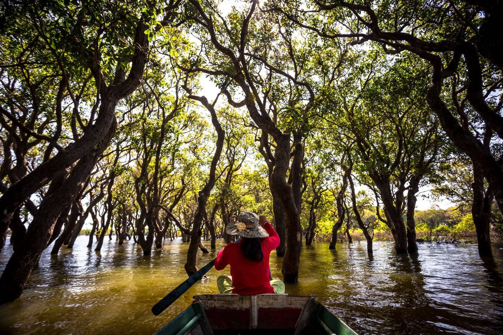 Frau paddelt mit Boot auf Tonle Sap See
