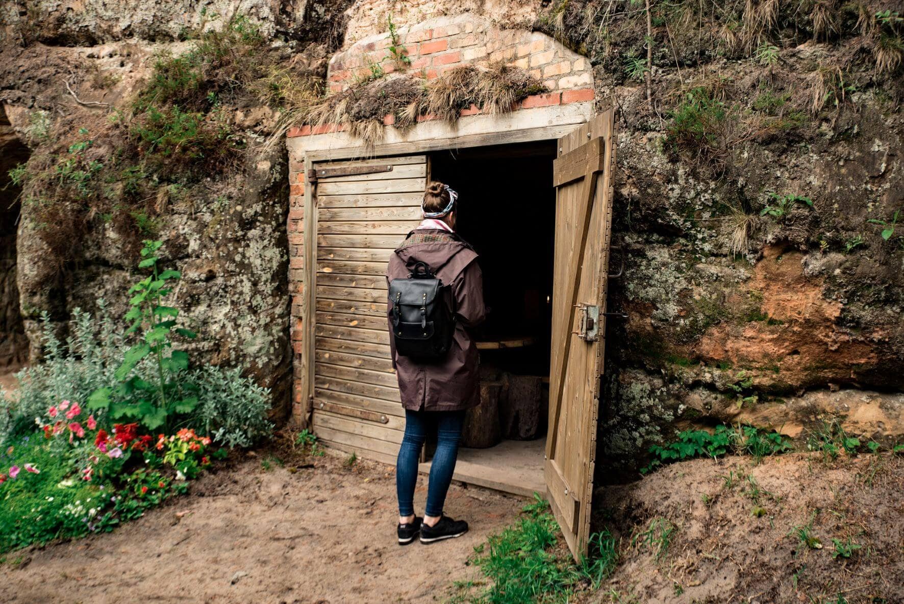 Besucherin vor Weinhöhle in Ligatne