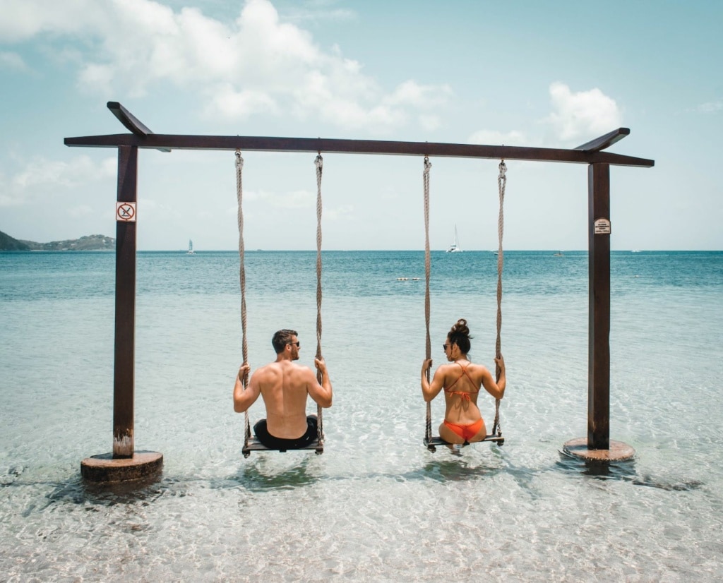 Paar sitzt auf Schaukel am Meer