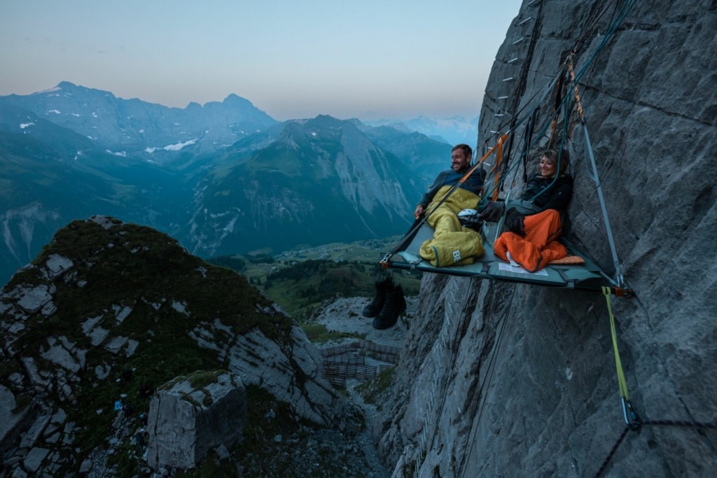 Mann und Frau auf Feldbett an Berg/Portaledge 