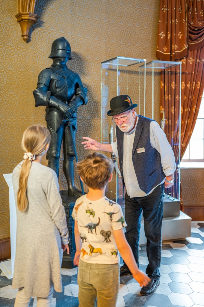 Herr STohmann zeigt bei der Führung auf dem Jagdschloss Granitz eine Ritterrüstung