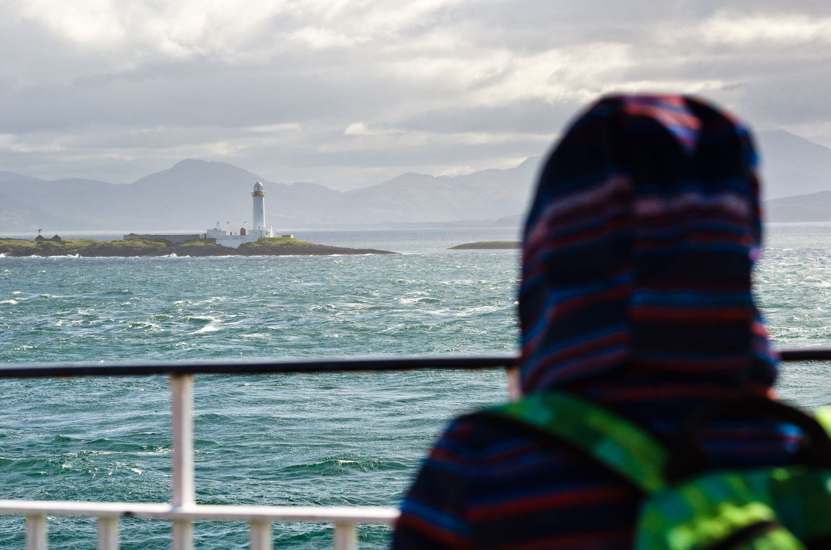 Tourist blickt auf Leuchtturm auf Lismore, Schottland