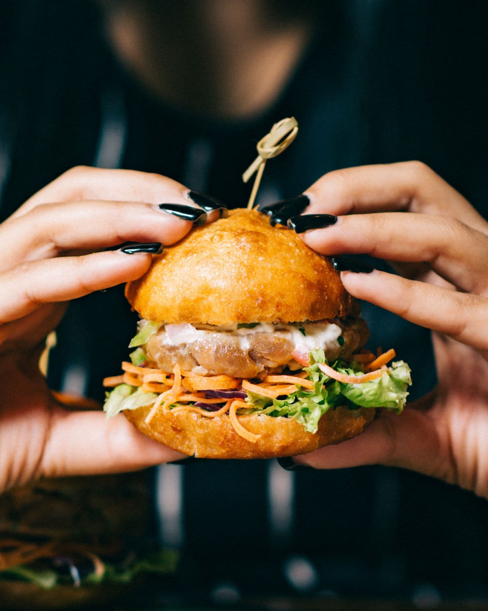 Frau hält Burger in der Hand