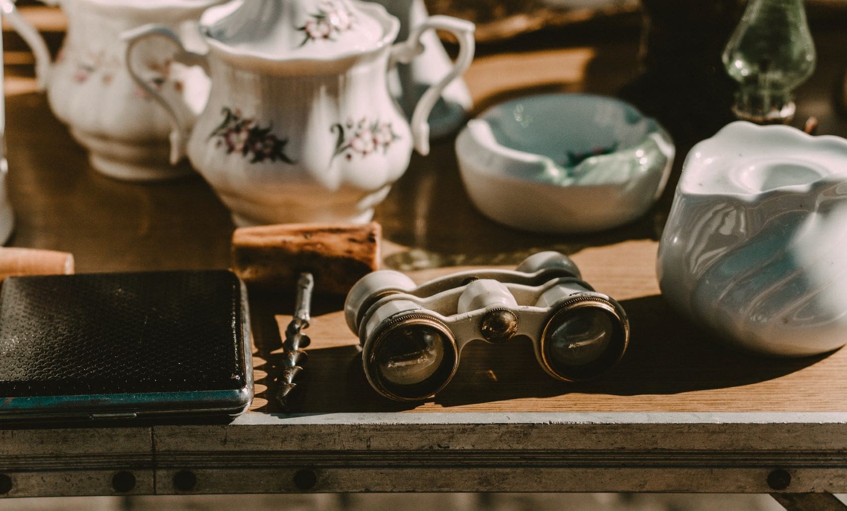 Porzellan und Fernglas auf Vintage-Flohmarkt