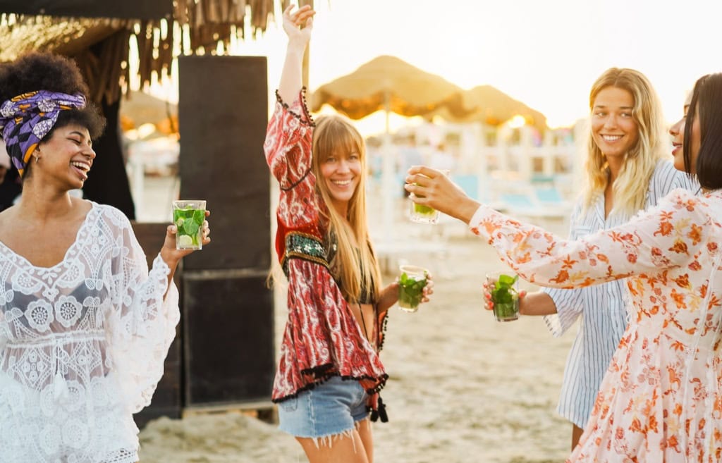 Frauen tanzen in einem Beach Club auf Mykonos