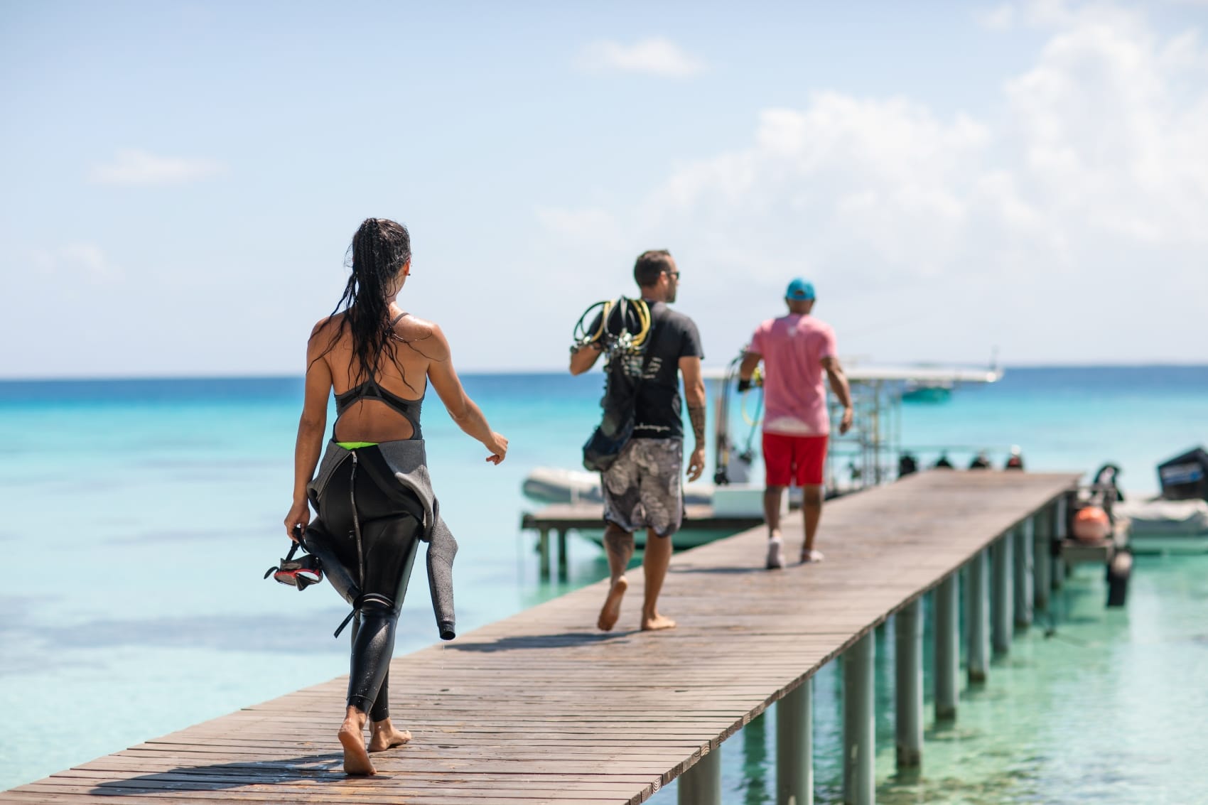 Taucher gehen über einen Steg auf Tahiti