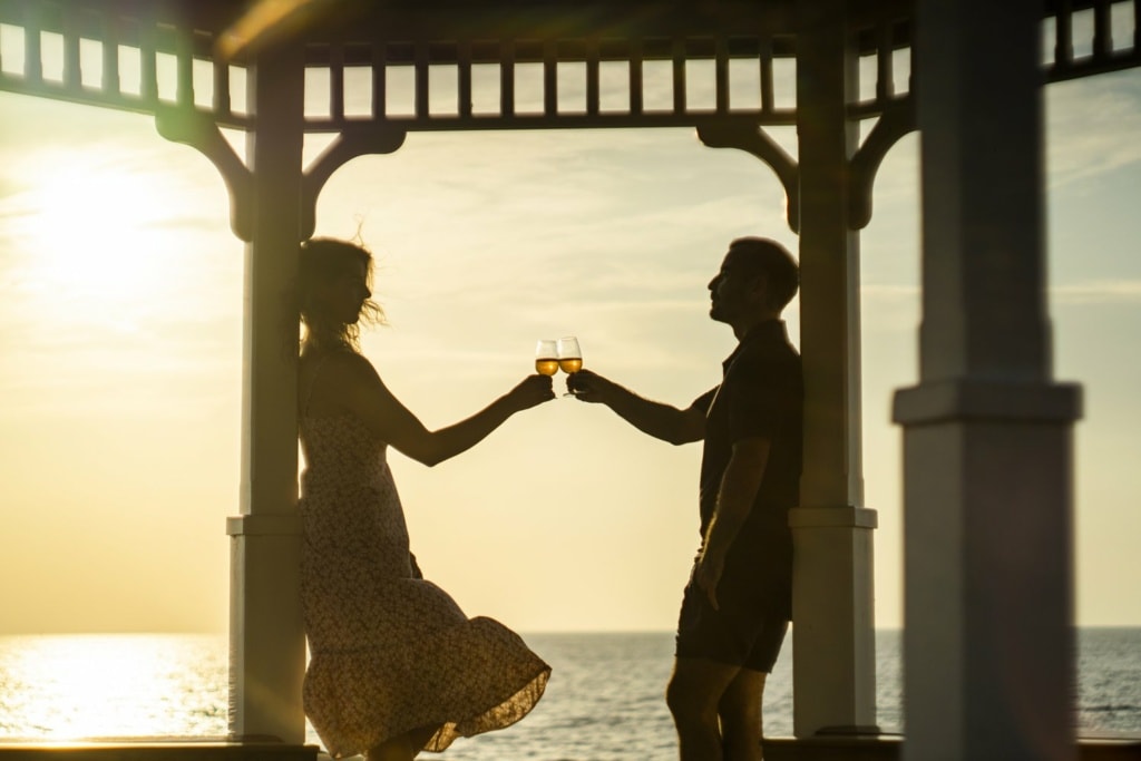 ein Pärchen genießt ein Glas Wein beim Sunset