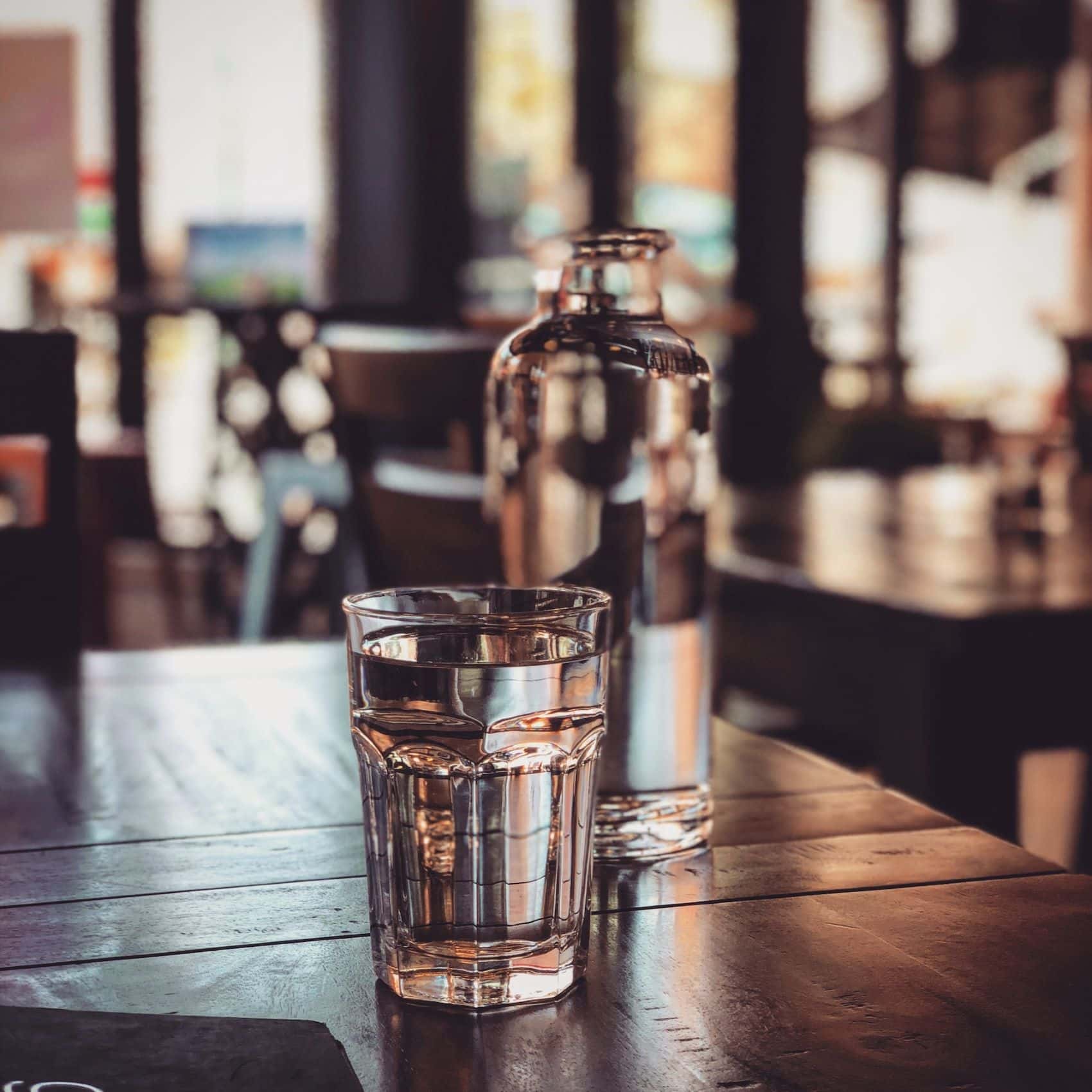 Karaffe und Glas Wasser auf Tisch