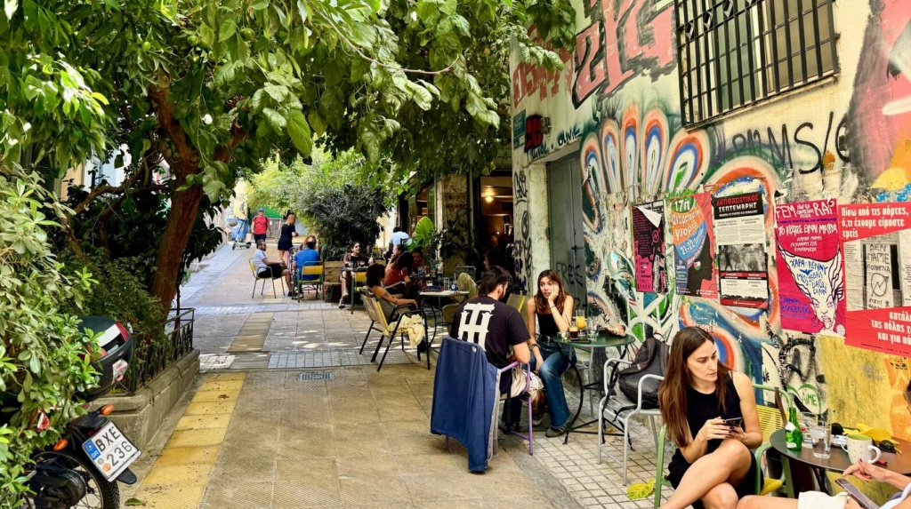 Junge Leute sitzen in Exarcheia, Athen, auf der Terrasse eines Cafes