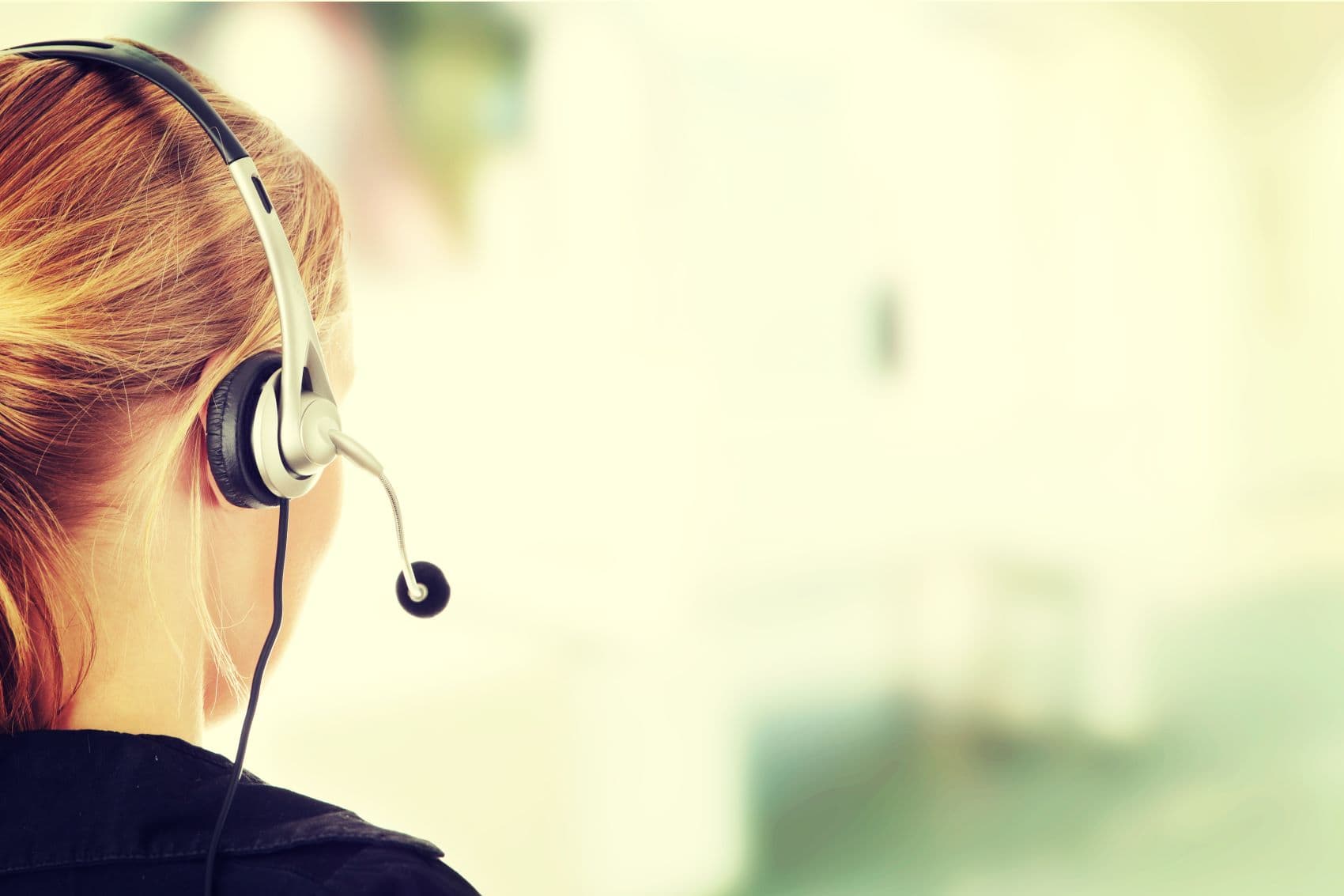Hotline-Beraterin mit Headset von hinten