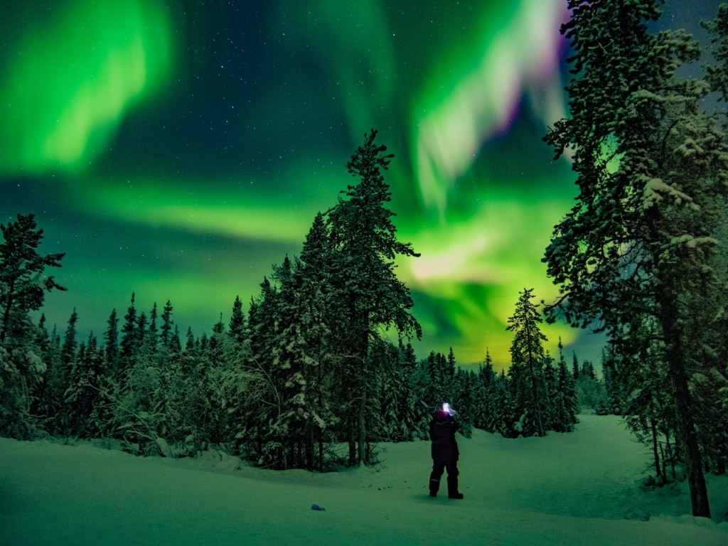 Mann unter Nordlichtern in Kanada