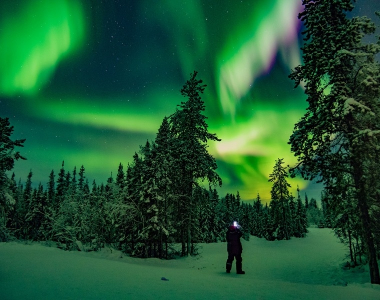 Mann unter Nordlichtern in Kanada