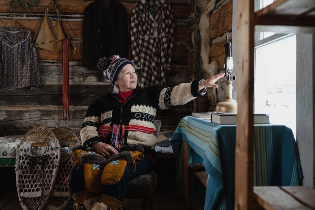 Person sitzt in Lodge von Métis Crossing, Tierfelle hängen an den Wänden.