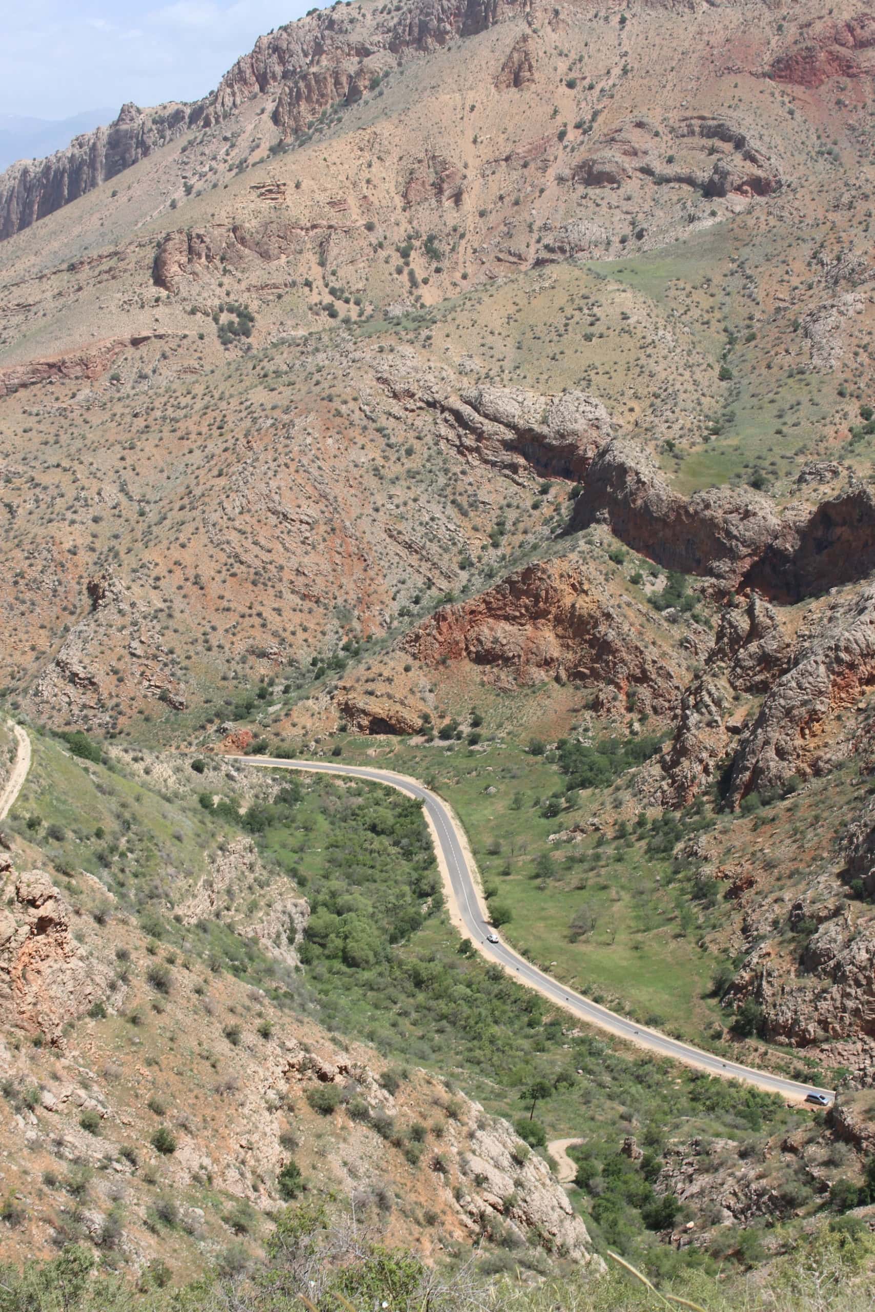 Durch die Berge in Armenien führt eine geschwungene Straße, aufgenommen von einem Hang