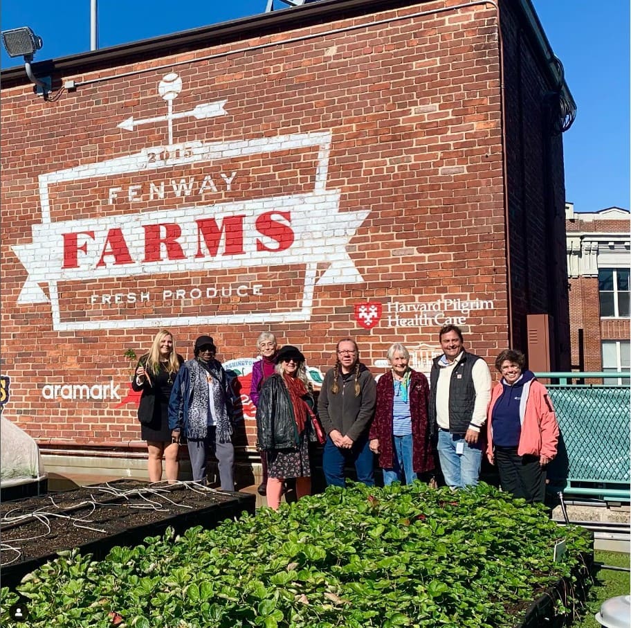 Menschen vor dem Logo der Fenway Farm in Boston
