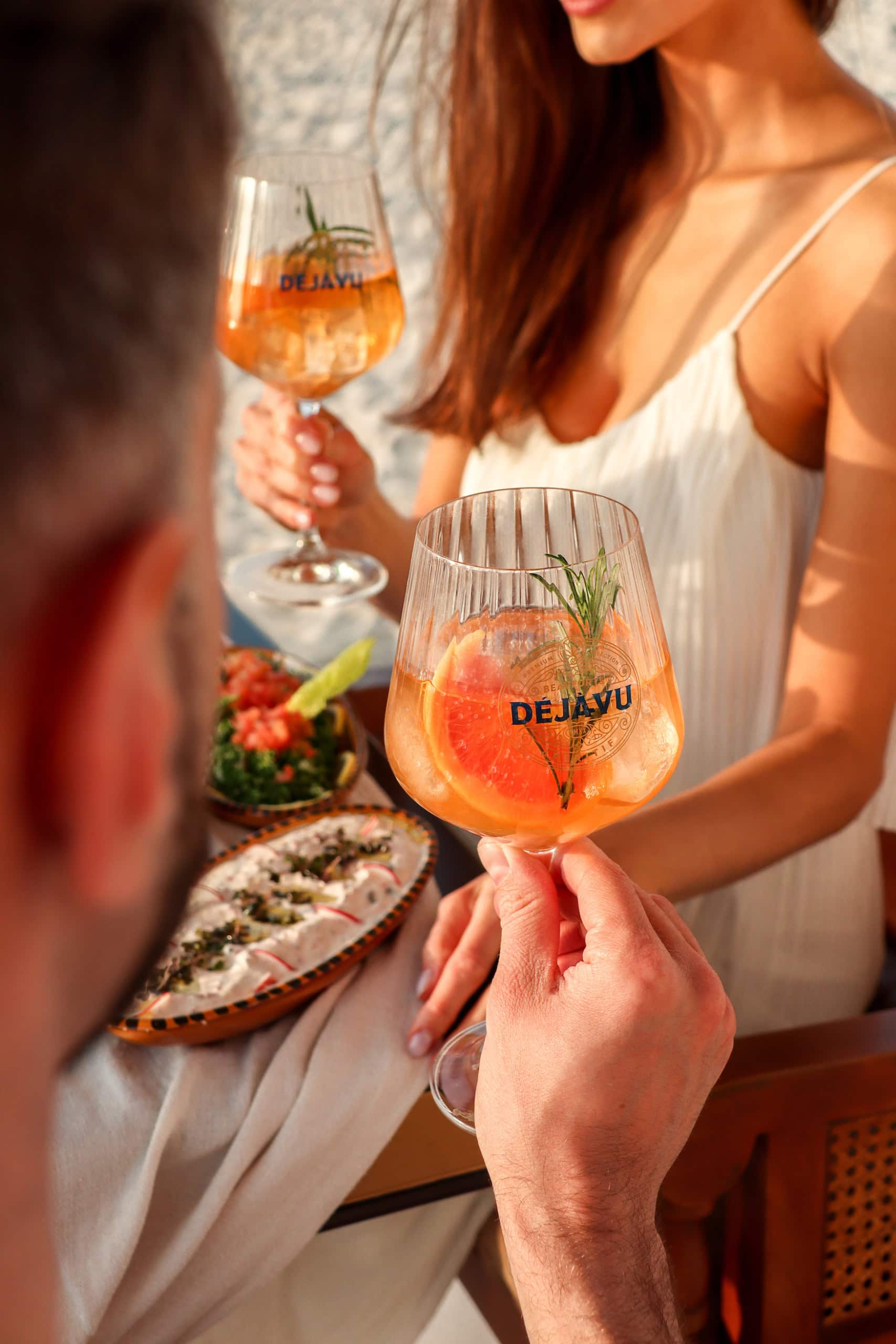 Frauen mit Sommerdrinks in Weingläsern, darauf die Aufschrift "Déjà-vu"