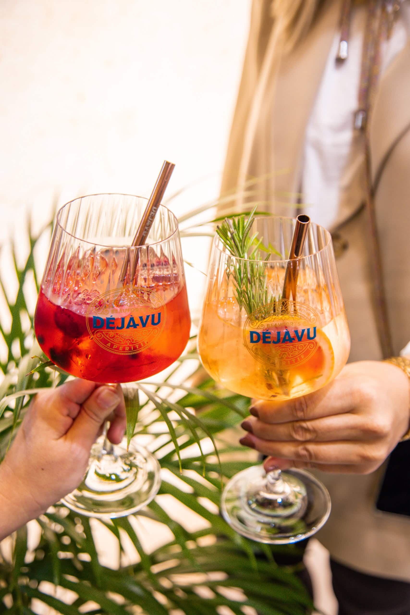 zwei Personen halten Gläser mit sommerlichen Drinks, darauf jeweils die Aufschrift Déjà-vu.