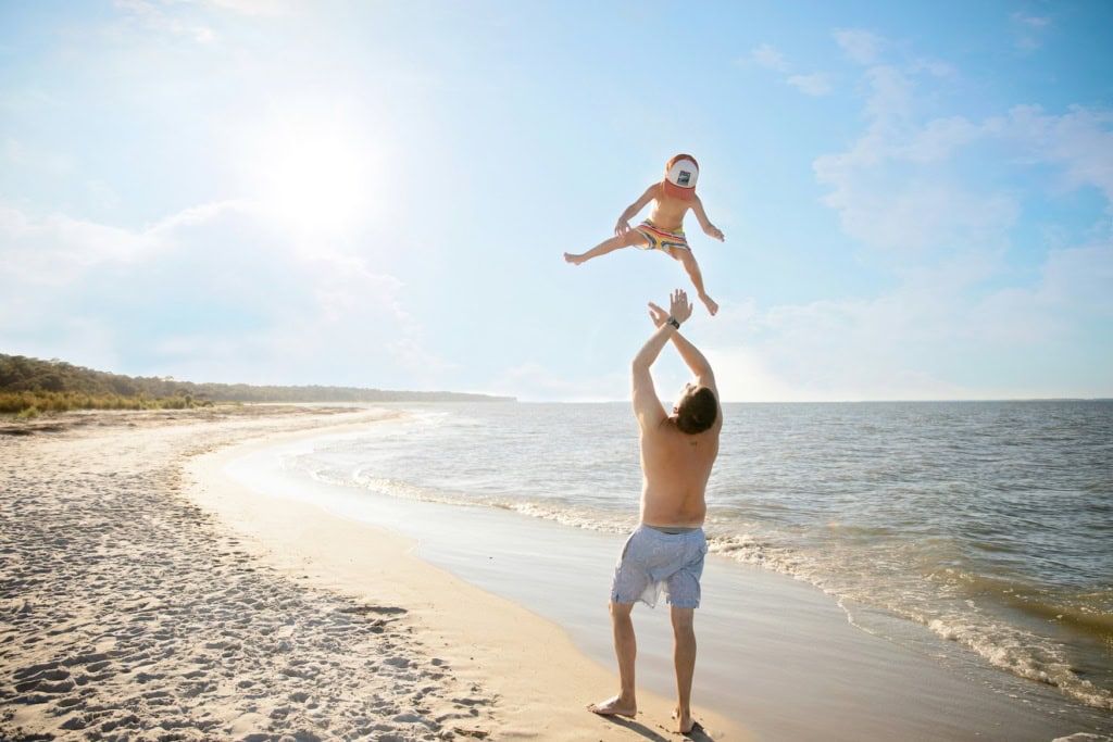 Mann mit Kind am Strand