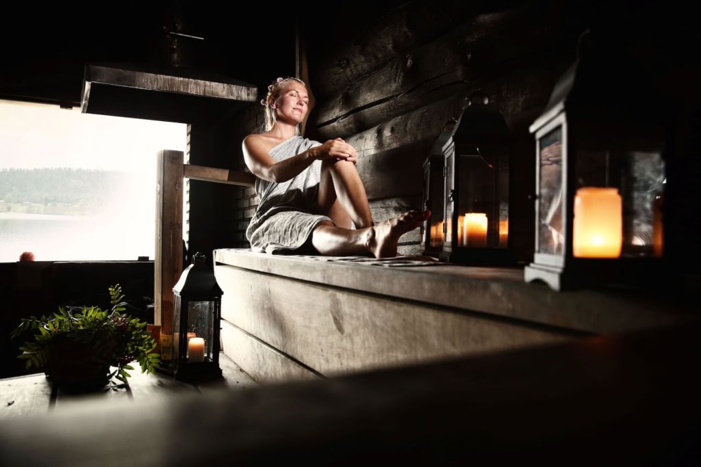 Eine Frau sitzt in der Sauna im Urlaub in Lappland