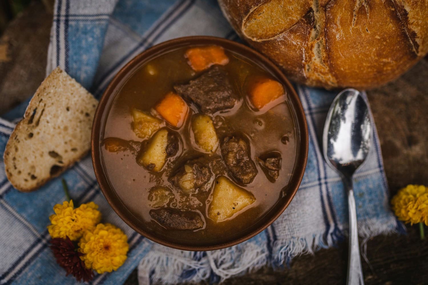 Eine Schüssel Eintopf mit Brot an der Seite