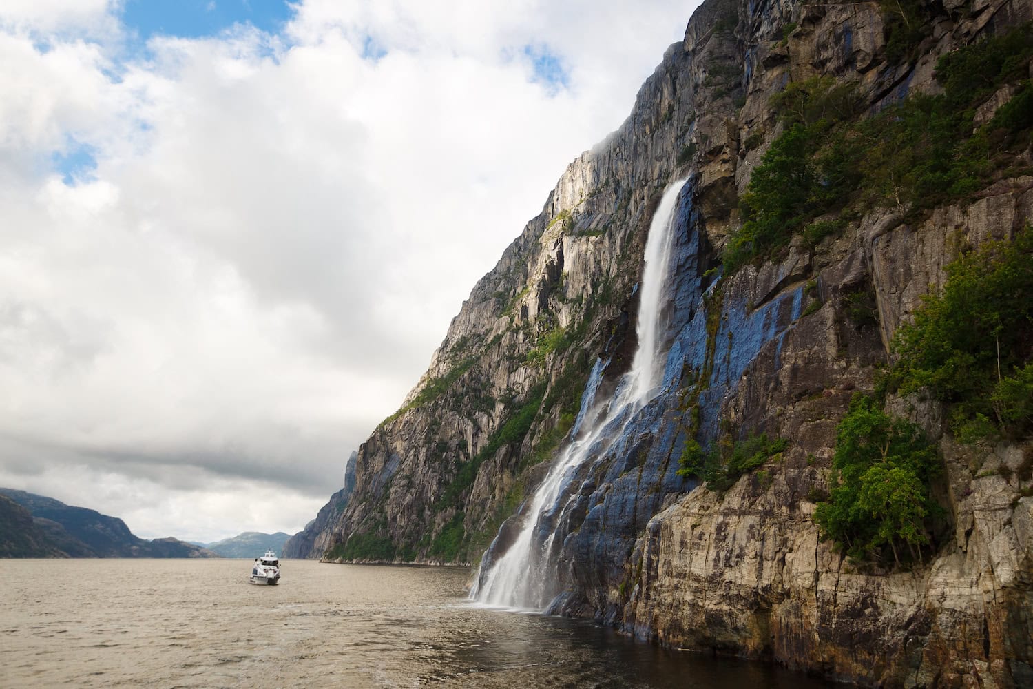 Der Hengjanefossen Wasserfall in Norwegen mit einem Boot im Wasser