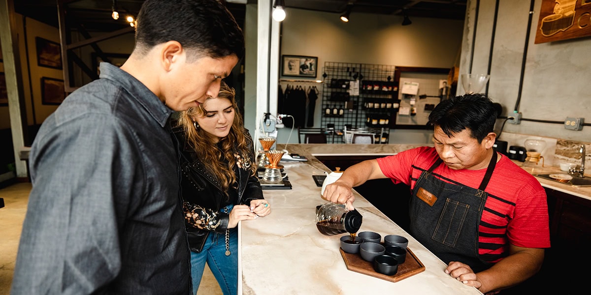 Ein Kellner schenkt zwei Personen Kaffee in Panama ein