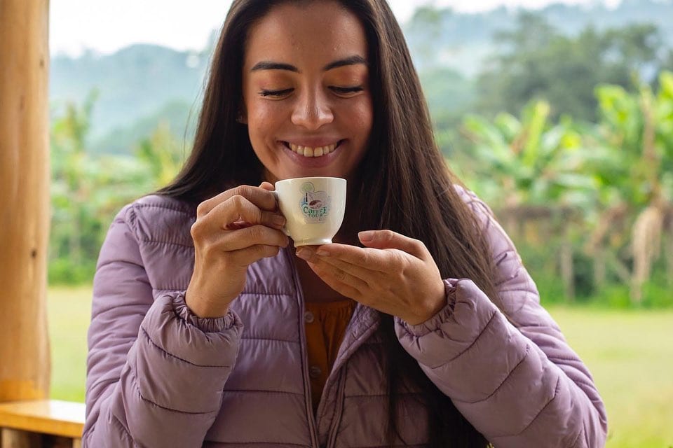Eine Frau mit einer kleinen Tasse Kaffee in derHand in der Dominikanischen Republik