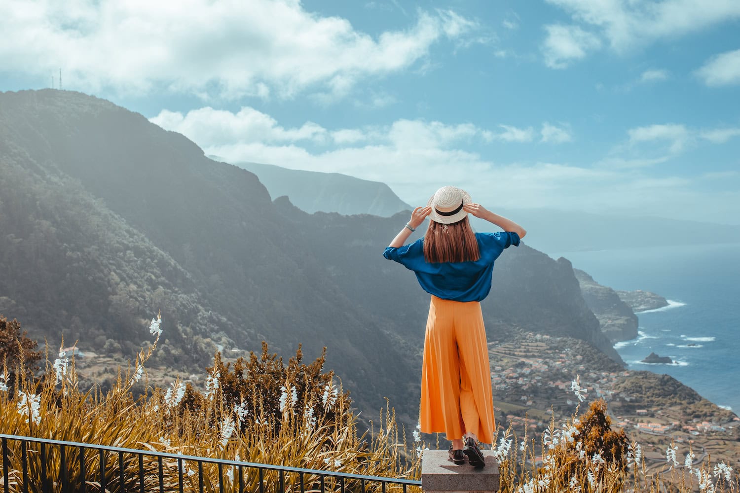 Eine Frau steht auf einem Stein und schaut auf den Ausblick von Madeira