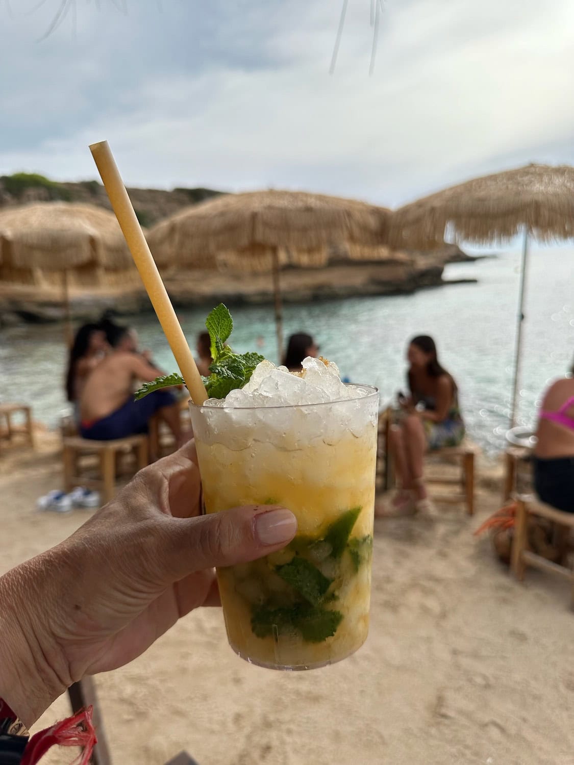 Ein Margarita in der Hand und im Hintergrund der Strand der Cala Escondida