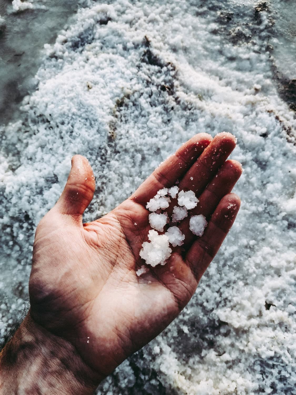 Salz in einer Hand über dem Meer