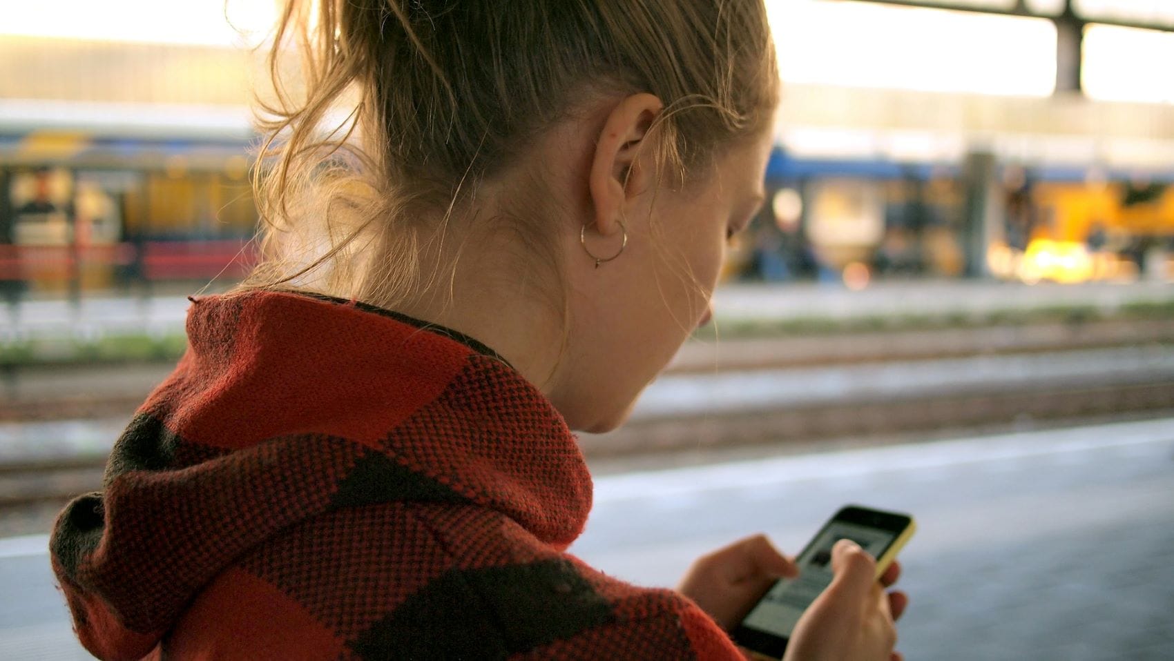 Junge Frau blickt auf ihr Handy