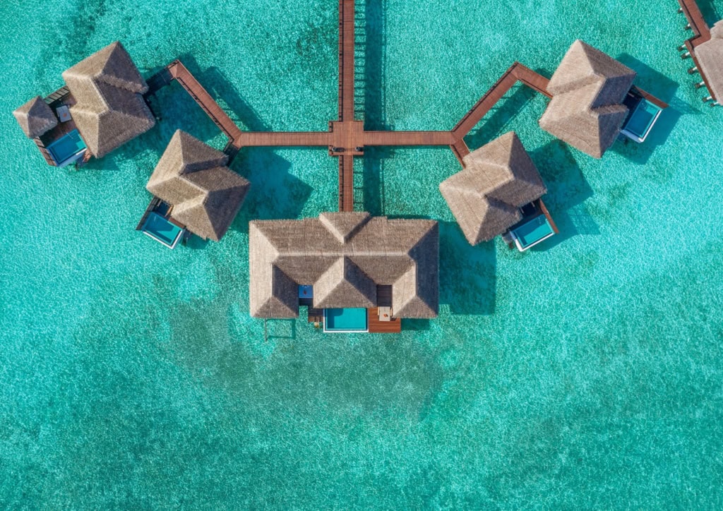 Mehrere Villen des Sheraton Maldives Full Moon Resort & Spa stehen auf dem Wasser.