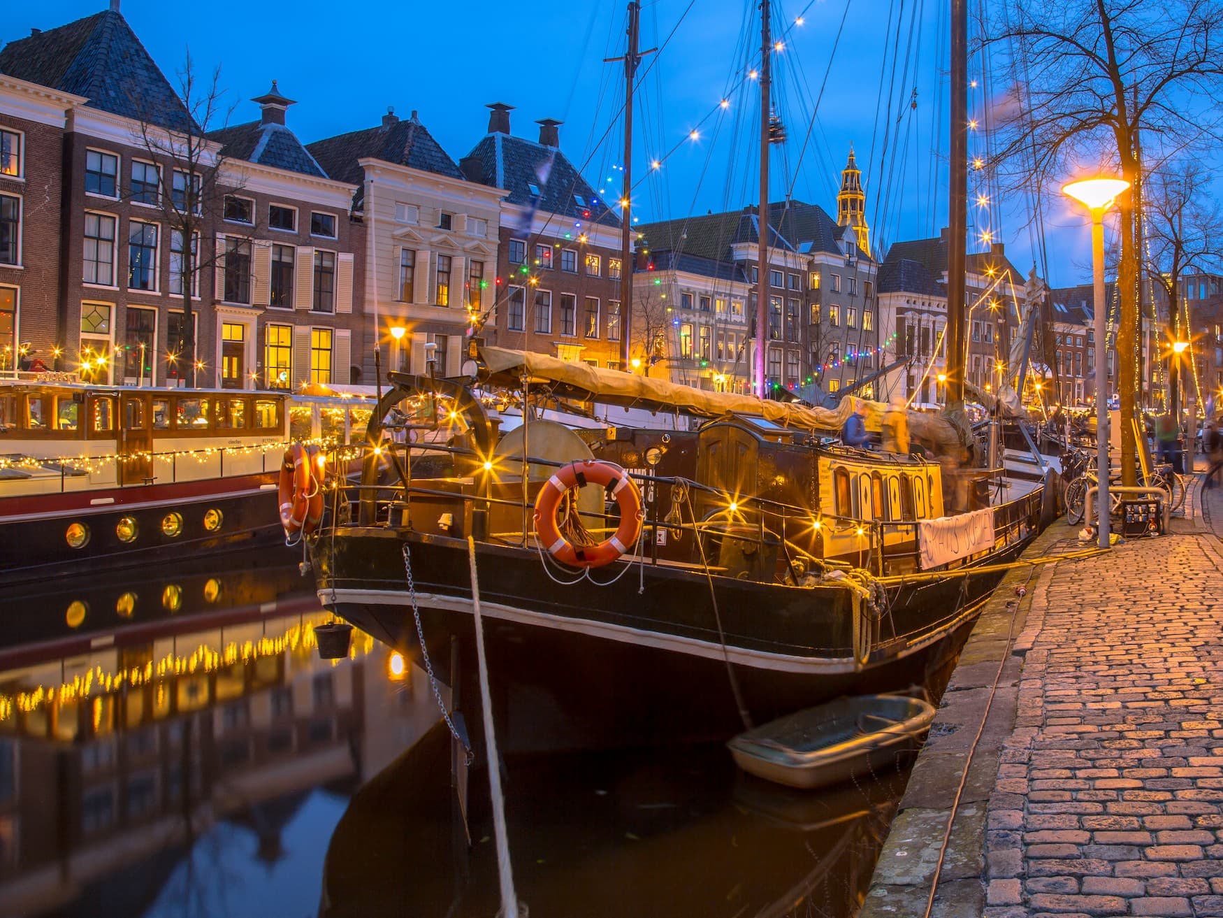 Festlich beleuchtete Segelschiffe auf einem Kanal in Groningen.
