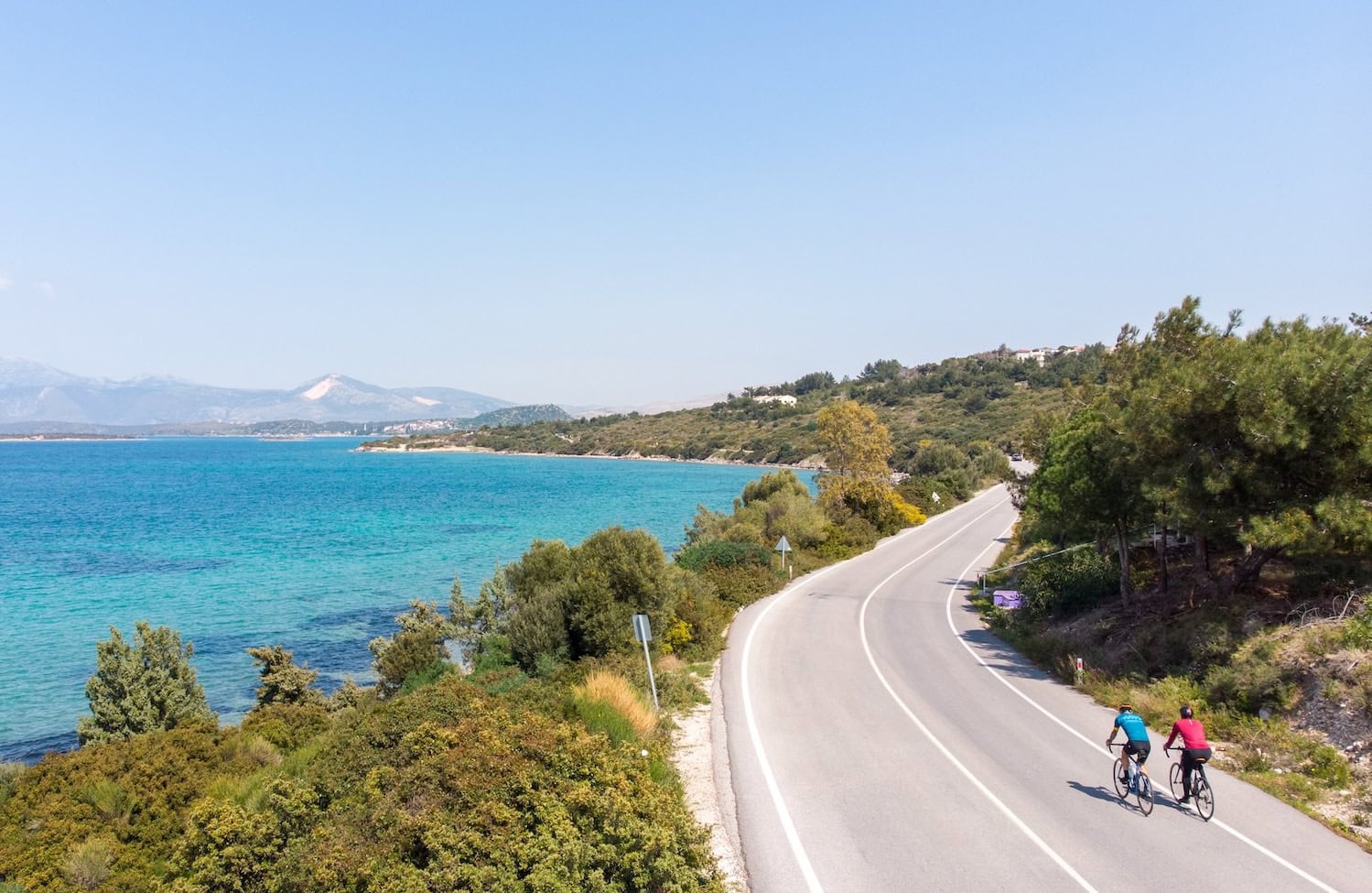 Zwei Radfahrer auf einer Straße an der Küste. Auch Radfahren gehört in der Türkei zu den Outdoor-Erlebnissen.