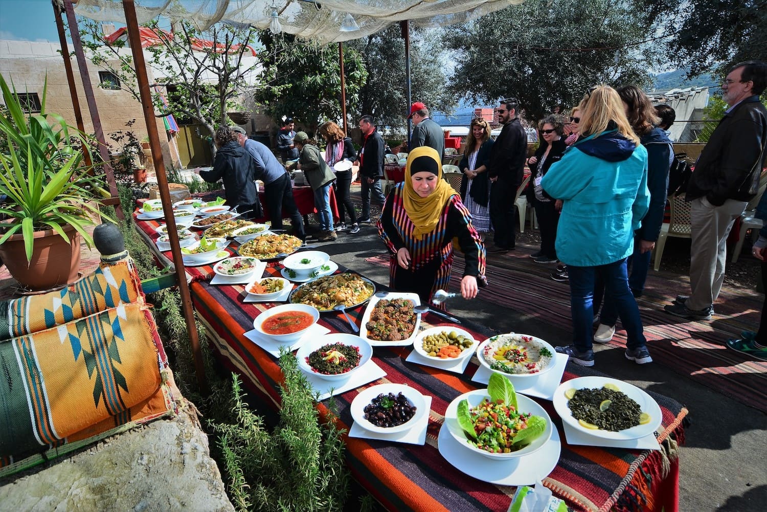 Traditionelle jordanische Gerichte auf einer langen Tafel im Freien.