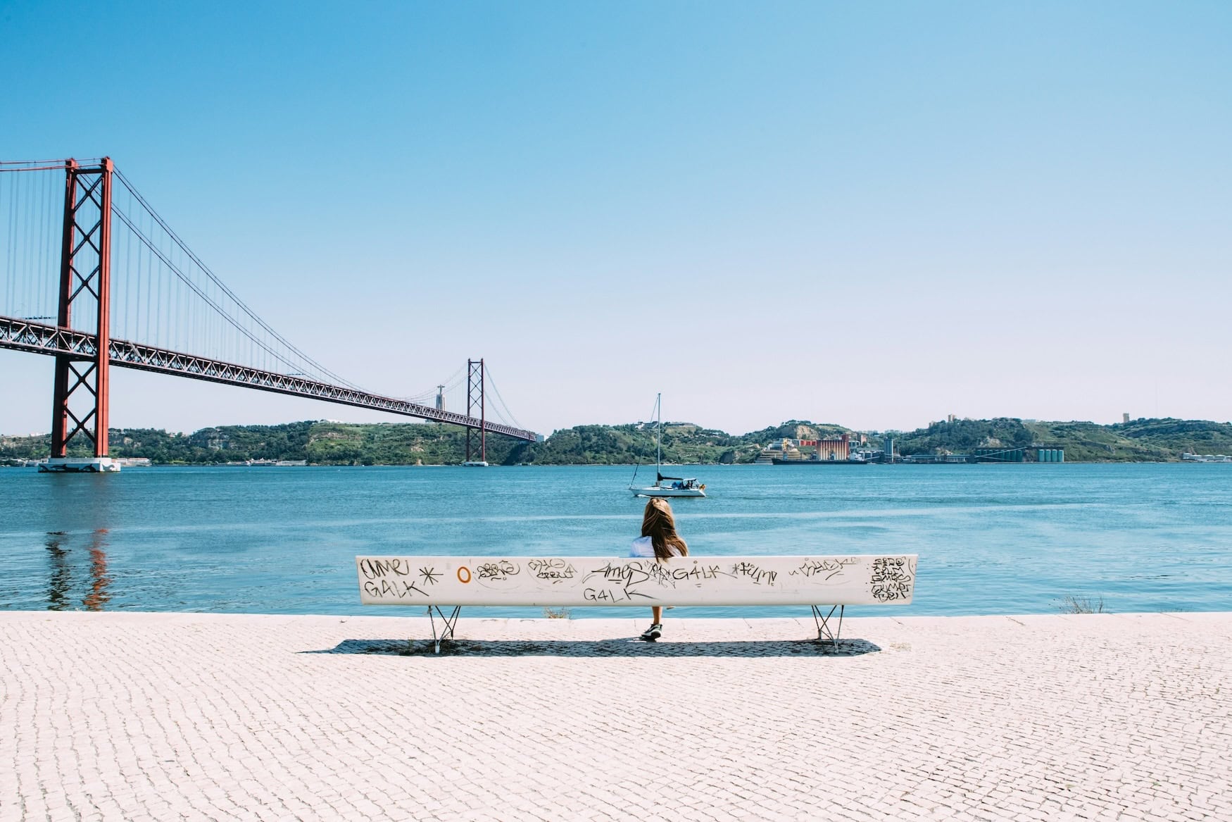 Frau sitzt am Tejo in Lissabon
