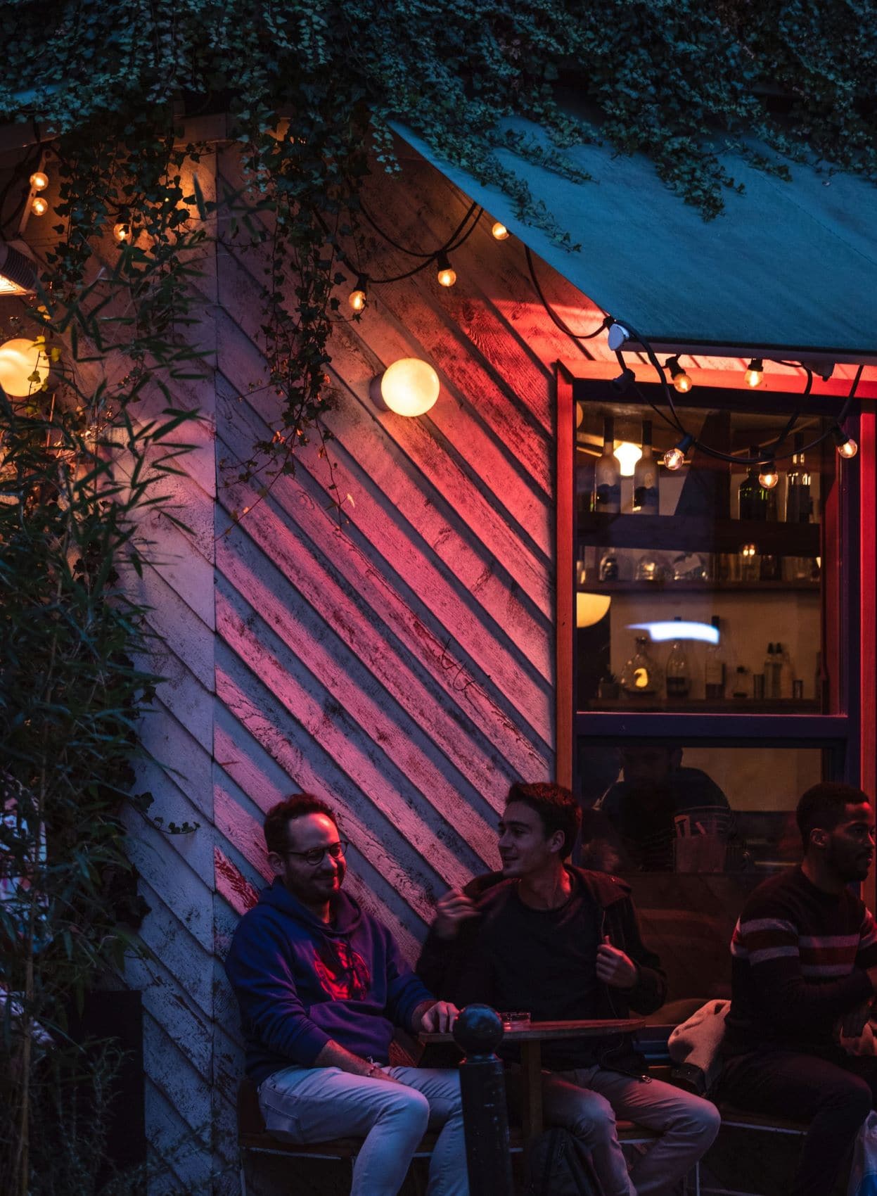 Zwei Männer sitzen an einem Tisch im Außenbereich in einer Bar in Paris