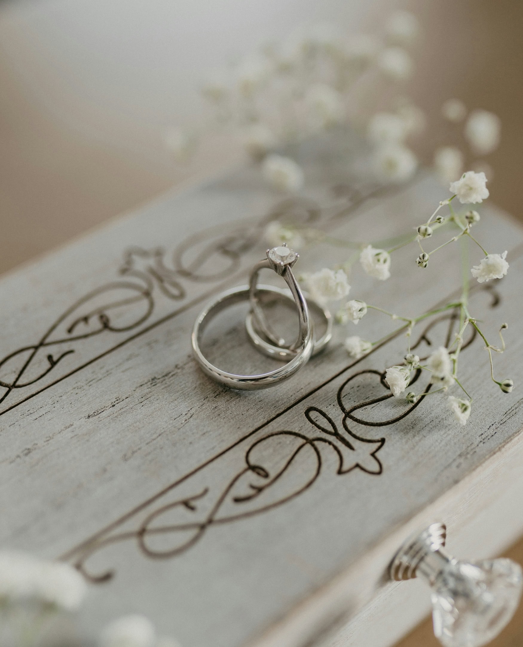 zwei Hochzeitsringe und Blumen
