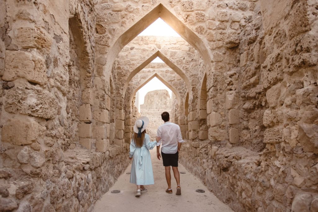 Mann und Frau flanieren durch die Festung Qal at al in Bahrain