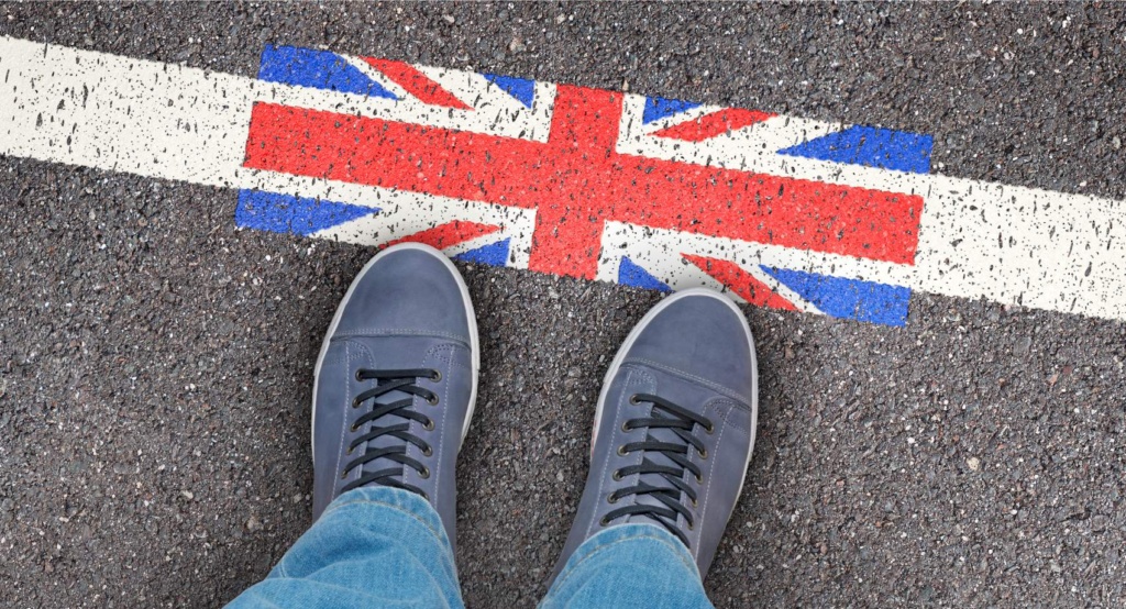 Person steht vor Piktogramm mit Großbritannien-Flagge, auf Straße