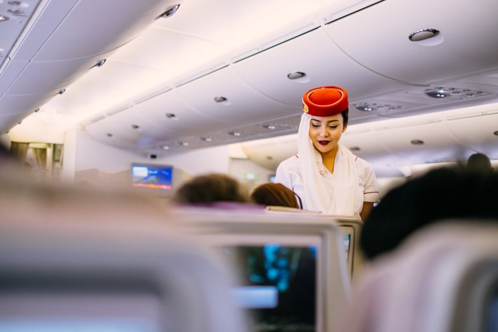 Eine Emirates-Stewardess serviert Essen.