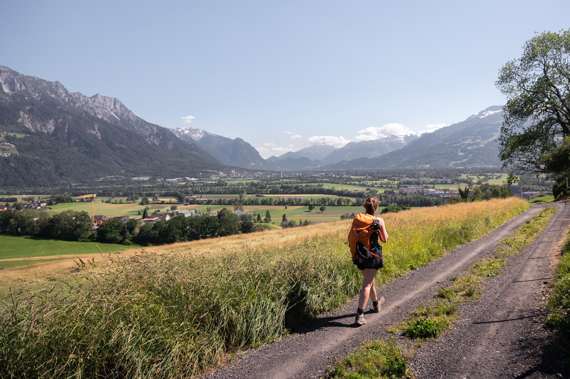 Eine Frau läuft auf einem idyllischen Weg – das perfekte Erlebnis im Liechtenstein-Urlaub.