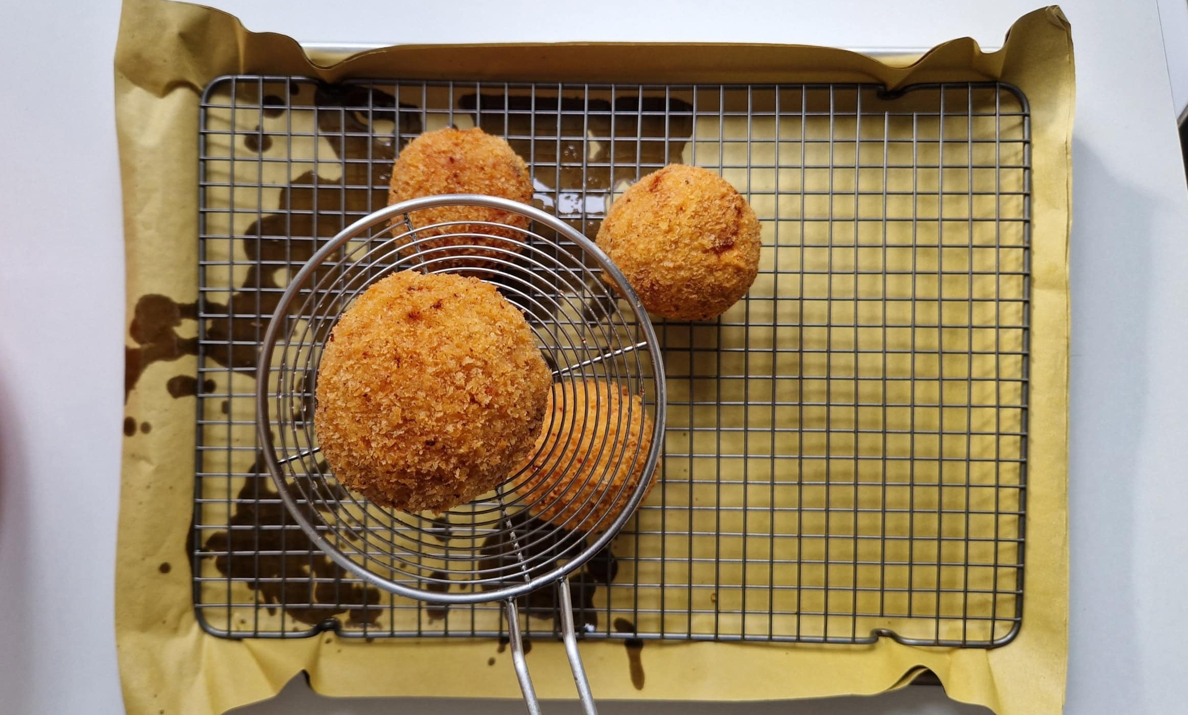 Arancini mit Kimchi-Reis werden frittiert.
