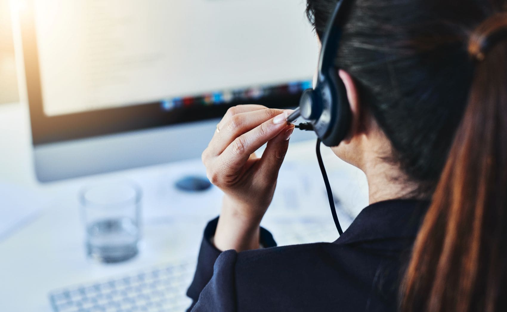 Hotline: Frau mit Headset vor einem Rechner