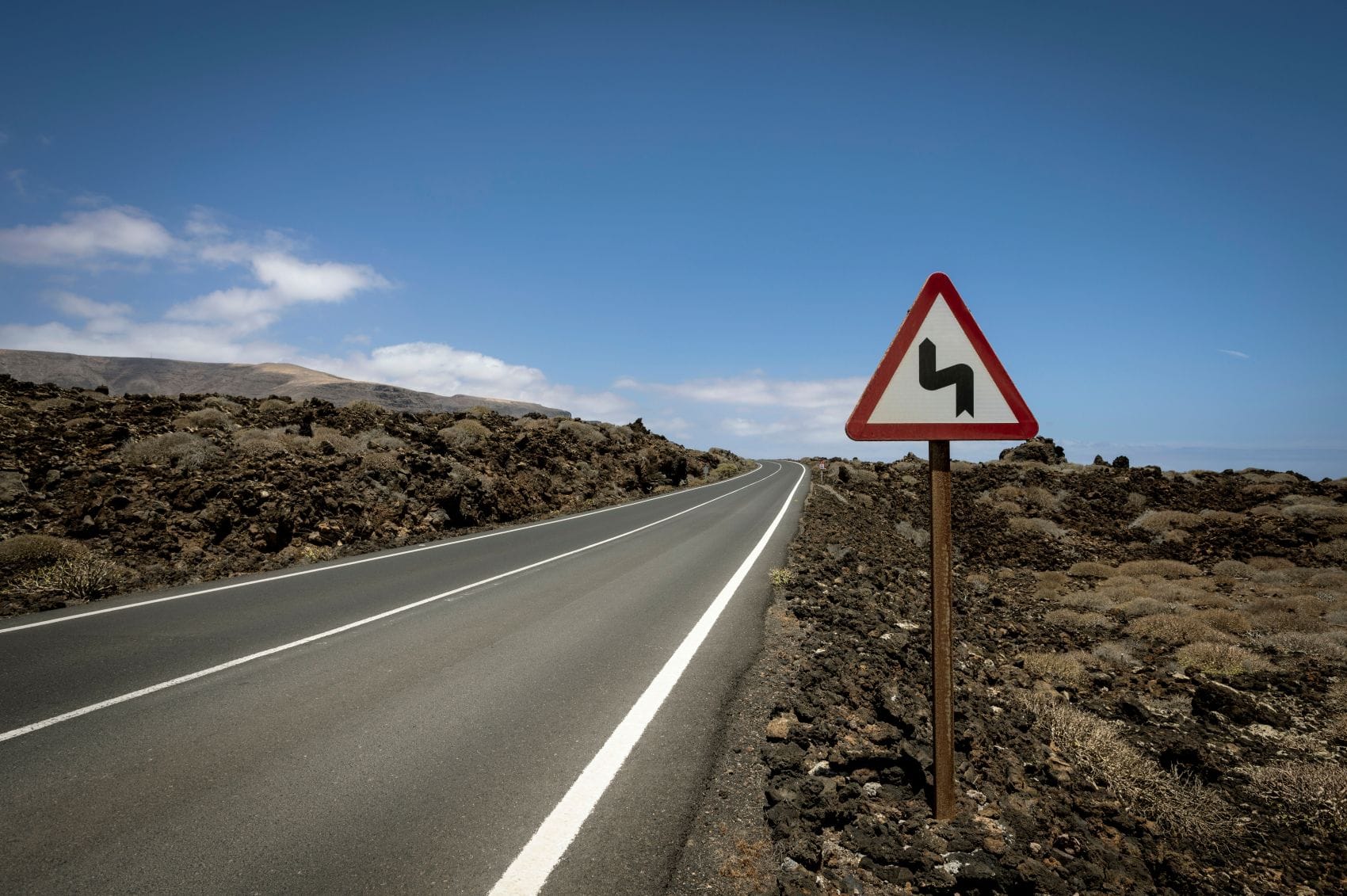Kurven-Hinweisschild auf Landstraße auf Lanzarote