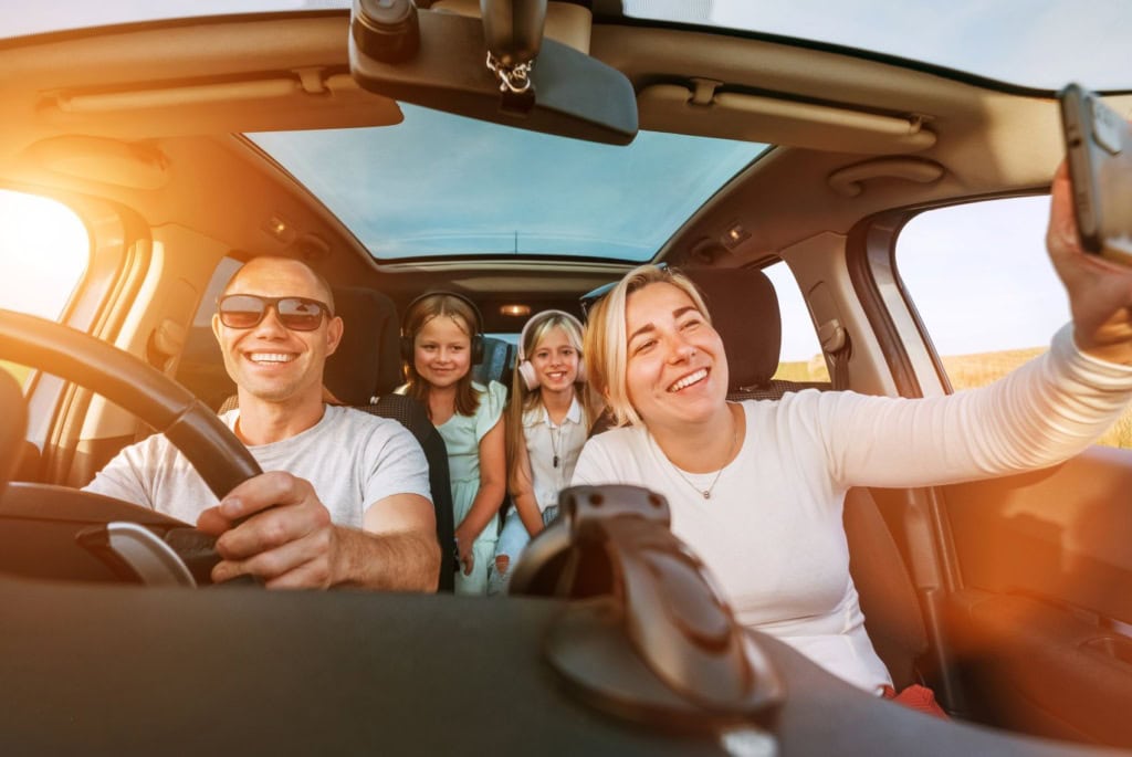 Vierköpfige Familie lachend im Auto