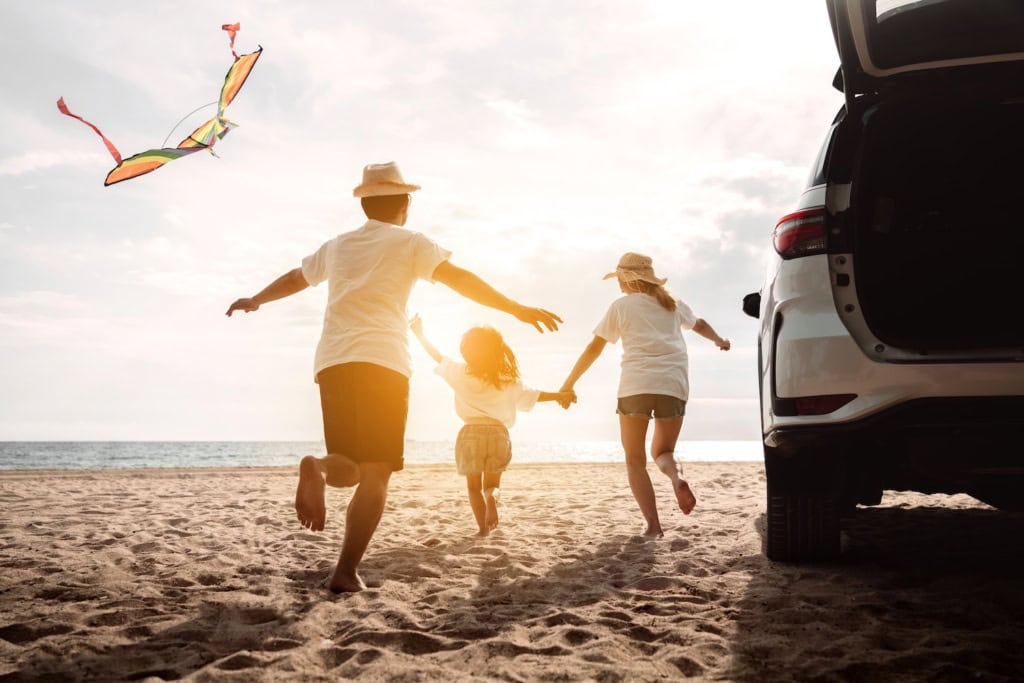 Familie mit Auto am Strand